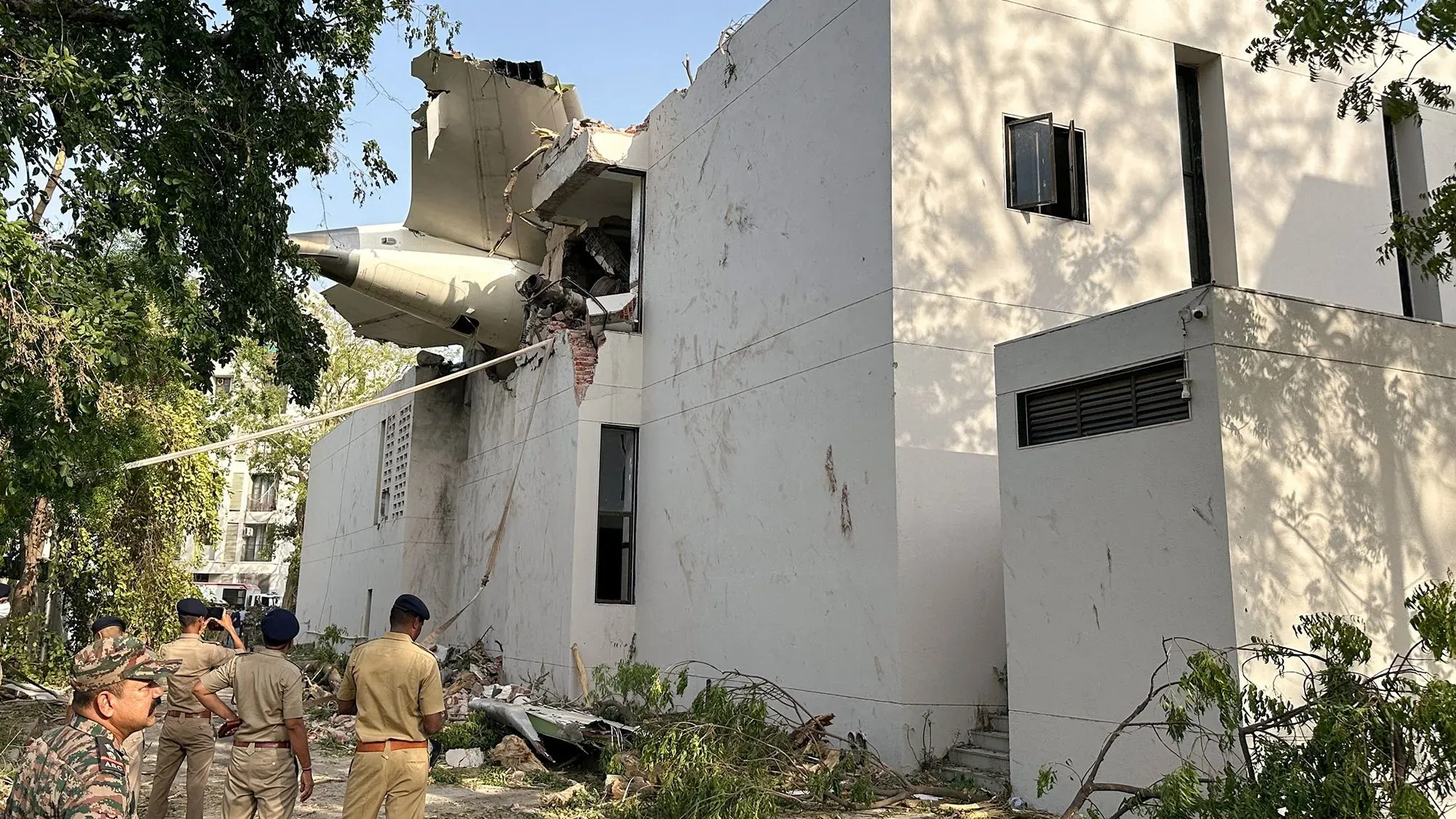 تحطم طائرة بوينغ 787-8 في مبنى سكني بعد الإقلاع، مما أسفر عن مقتل 270 شخصًا، مع وجود فرق الطوارئ في موقع الحادث.