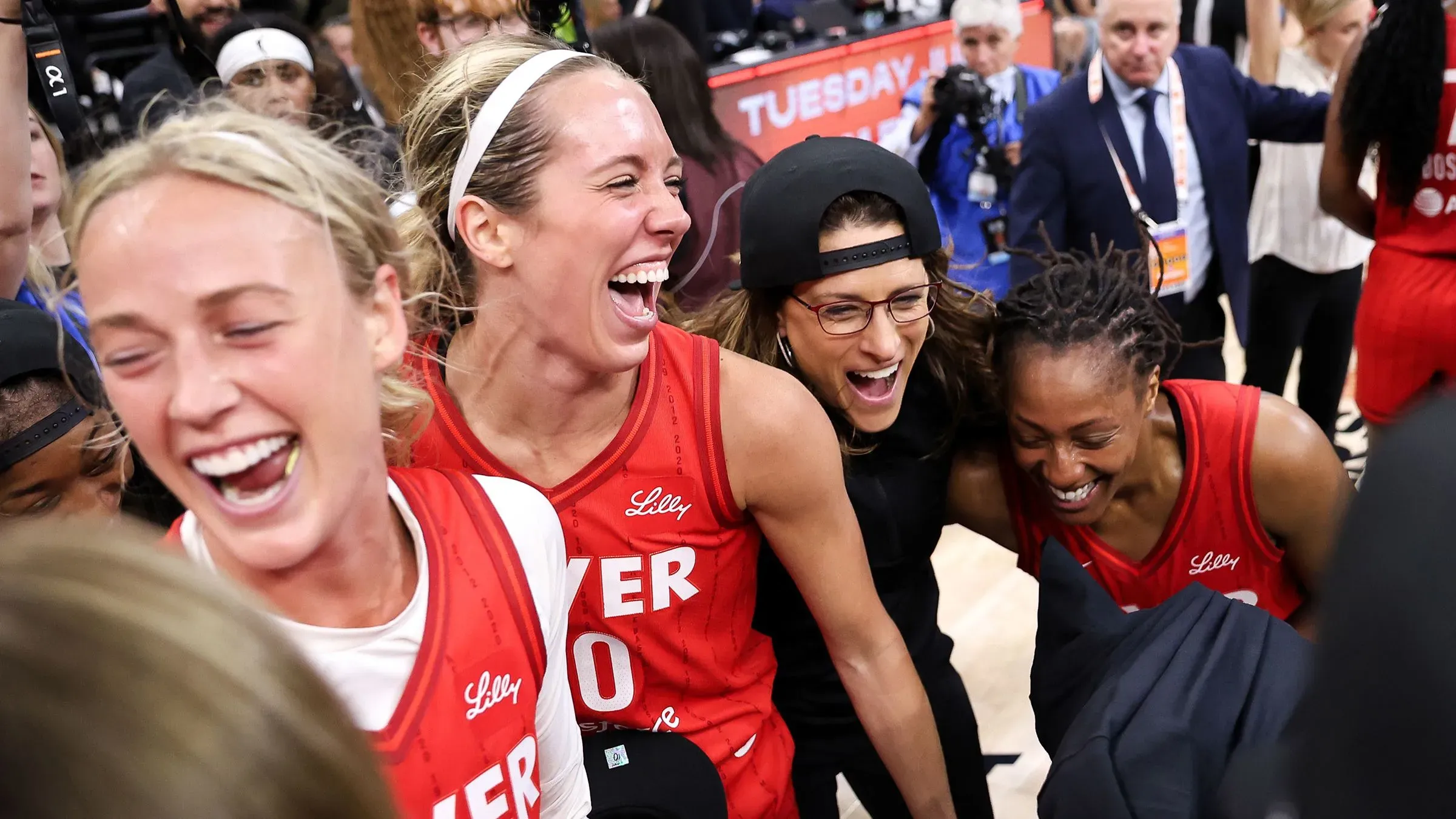 فرحة لاعبات فريق إنديانا فيفر بعد الفوز بكأس المفوض، مع ابتسامات وضحكات تعكس روح الفريق في أجواء احتفالية.