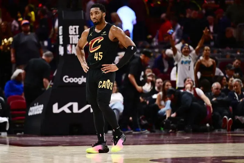 لاعب كليفلاند كافالييرز دونوفان ميتشل يقف على أرض الملعب بعد الهزيمة، مع جمهور خلفه يعبر عن مشاعر الإحباط.