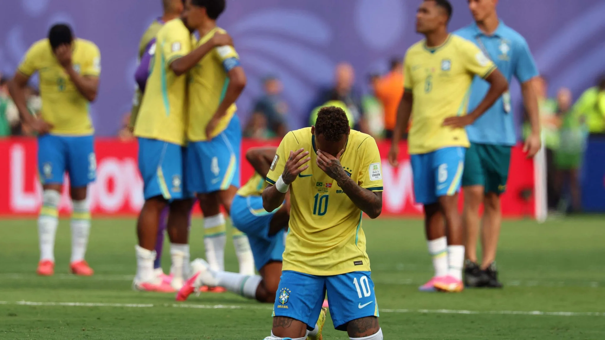 نيمار يرتدي قميص البرازيل رقم 10 يظهر تأثره وحزنه بعد خروج المنتخب من كأس العالم، مع لاعبين آخرين في الخلفية.