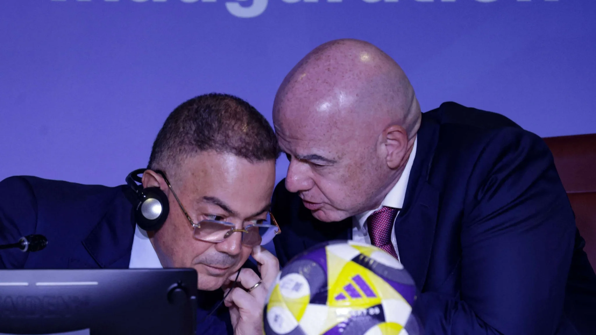 جياني إنفانتينو رئيس الفيفا يتحدث مع مسؤول خلال مؤتمر صحفي عن استضافة المغرب لكأس العالم 2030.