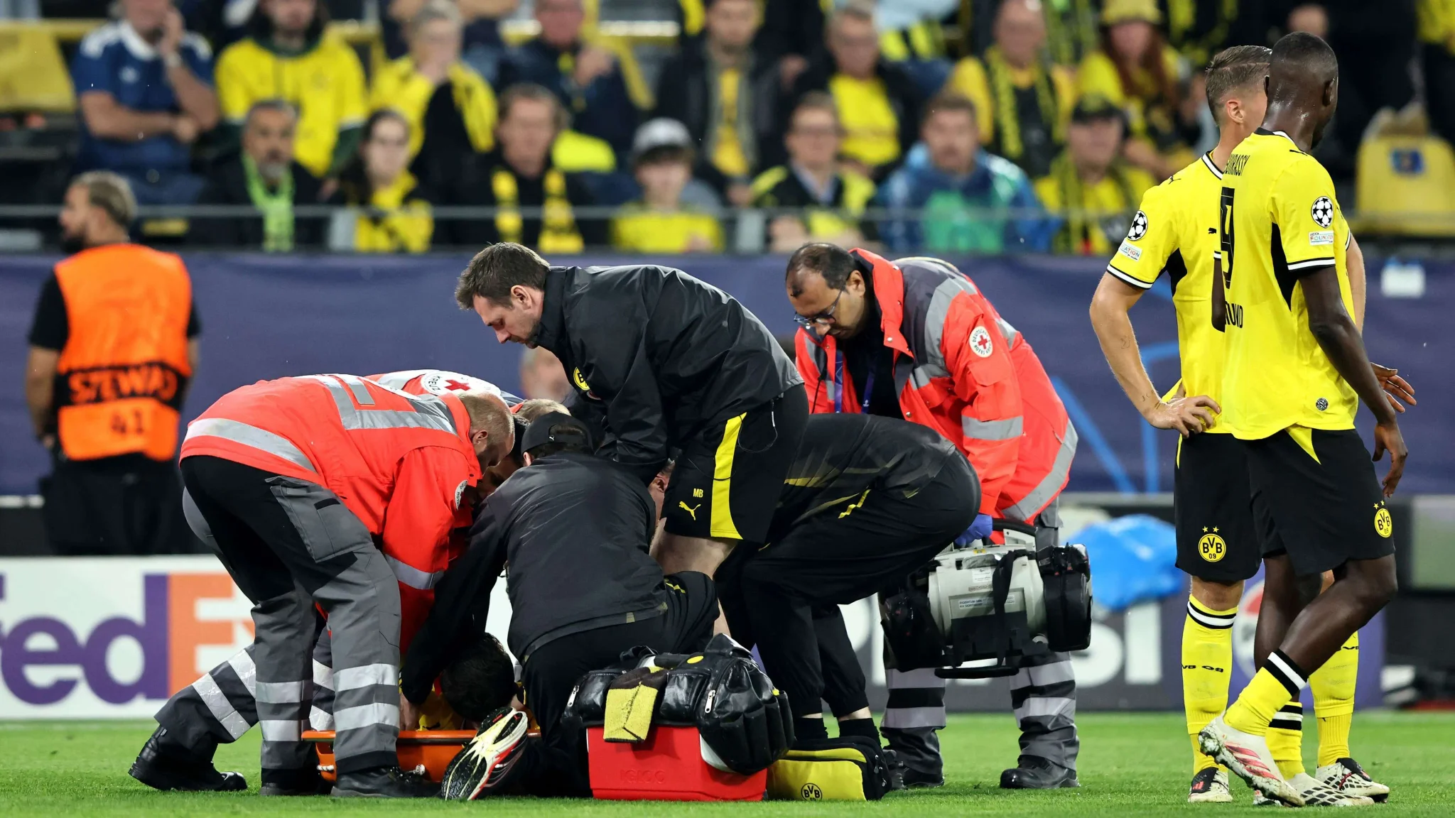 طاقم طبي يعالج اللاعب اليوناني الشاب Karetsas على أرض ملعب Signal Iduna Park بعد إصابة خلال مباراة فريق بوروسيا دورتموند.