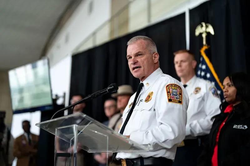 رئيس قسم الإطفاء في واشنطن يتحدث في مؤتمر صحفي حول جهود البحث والإنقاذ بعد حادث تحطم الطائرة والمروحية، مع وجود طاقم خلفه.