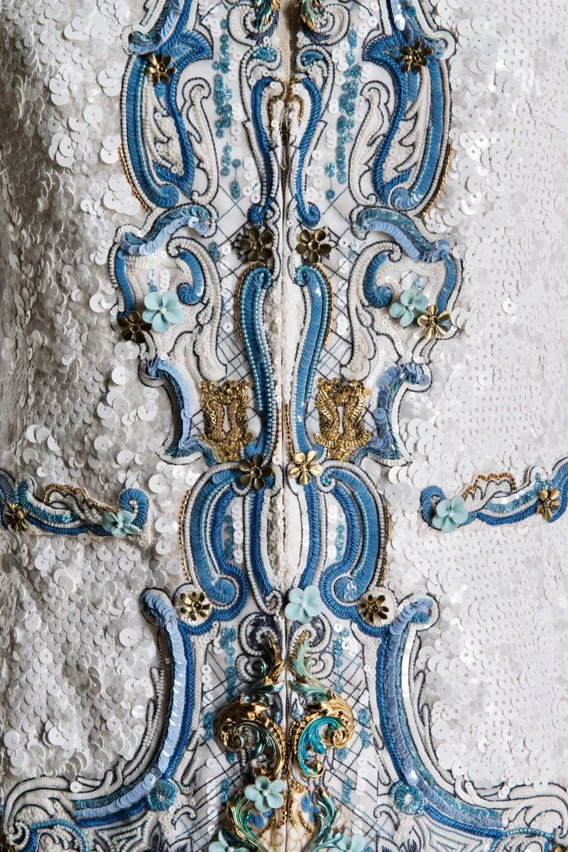 تفاصيل فاخرة لزي مصمم من شانيل، يتضمن تطريزات ملونة وزخارف معقدة تعكس الإلهام الفني والتاريخي للفن والموضة.