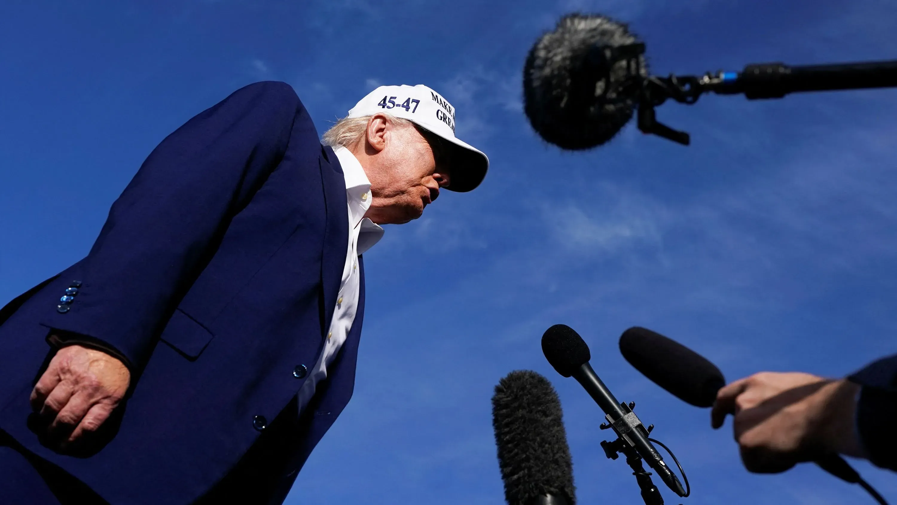 ترامب يتحدث للصحفيين، مرتديًا قبعة تحمل شعار "اجعل أمريكا عظيمة مرة أخرى"، وسط أجواء مشحونة بخصوص المفاوضات التجارية مع الاتحاد الأوروبي.