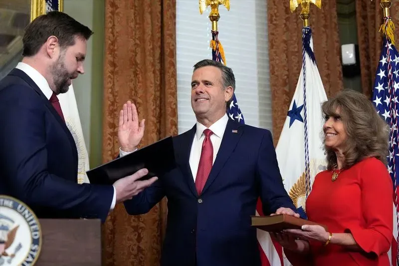 اجتماع لمجلس وزراء ترامب حيث يؤدي أحد الوزراء اليمين بحضور مسؤولين آخرين، مع العلميات العسكرية والأعلام خلفهم.