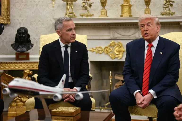 اجتماع بين الرئيس الأمريكي دونالد ترامب ورئيس الوزراء الكندي مارك كارني في المكتب البيضاوي، مع نموذج طائرة على الطاولة.