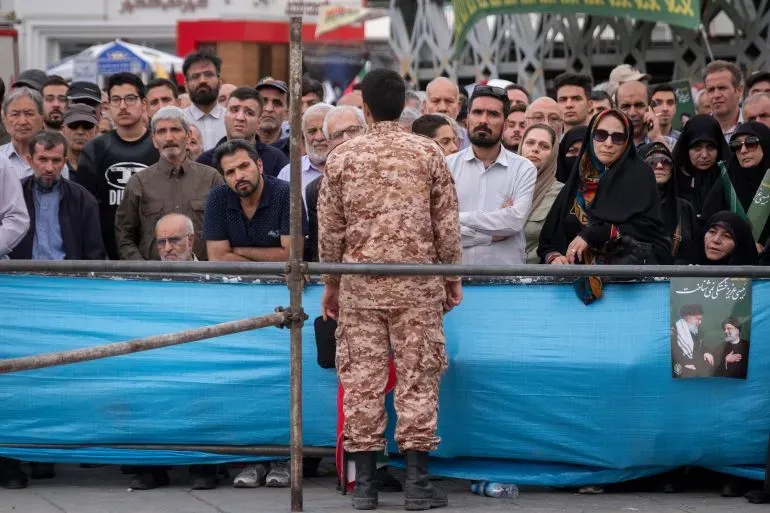 حشد من الناس يتابعون خطاباً من رجل يرتدي زي القوات المسلحة، في سياق حديث حول الإعدامات ضد أعضاء تنظيم داعش في إيران.