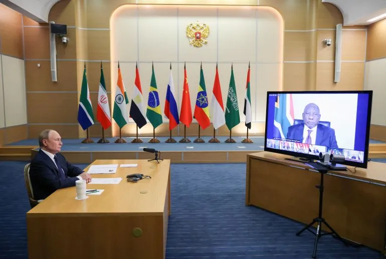 اجتماع وزراء خارجية مجموعة BRICS في نيودلهي، مع العلميات الوطنية خلفهم، حيث يناقشون التعاون الاقتصادي والقضايا الدولية.