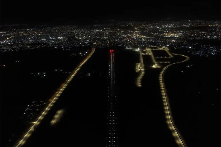 مطار الموصل الجديد مضاء ليلاً، يظهر مدرج الطائرات والمرافق المحيطة به، بعد إعادة ترميمه ليتحول إلى مركز للرحلات الداخلية والدولية.