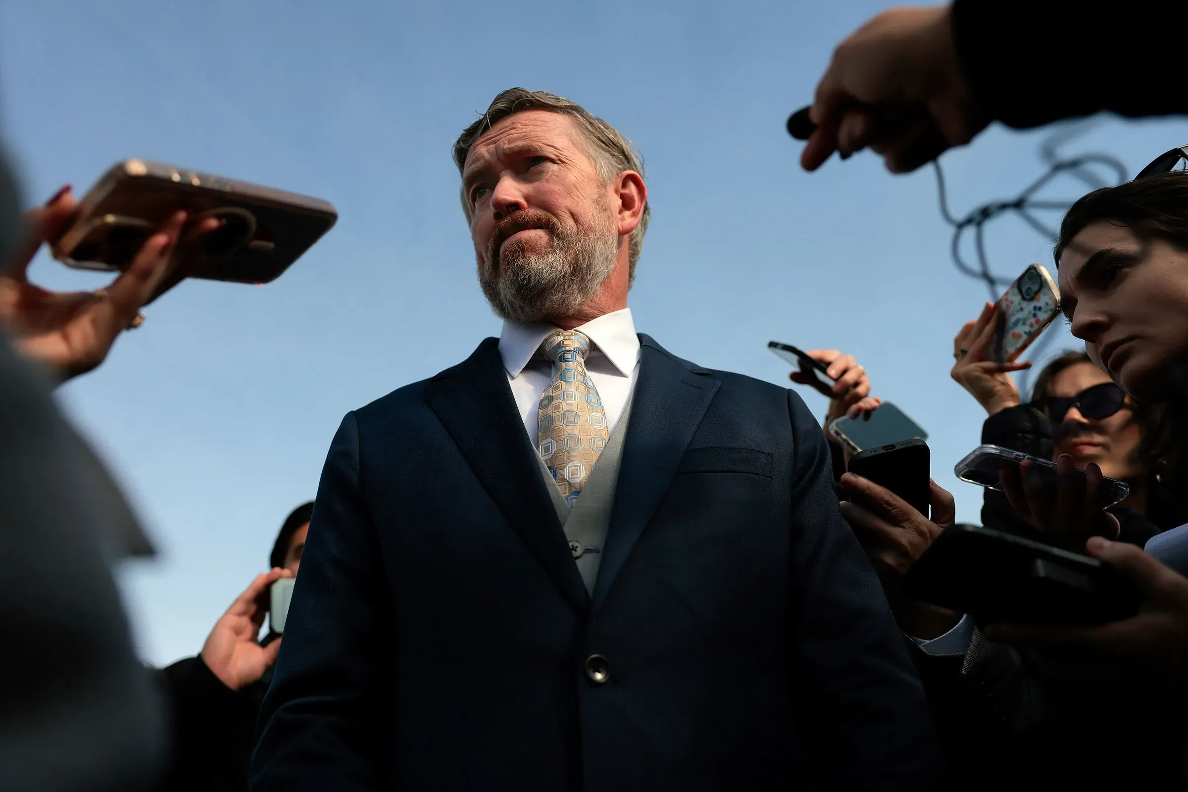 سيناتور إنديانا جين ليسينغ يتحدث مع الصحفيين، مع وجود هواتف محمولة تسجل الحوار، معبرة عن معارضتها لسياسات ترامب.