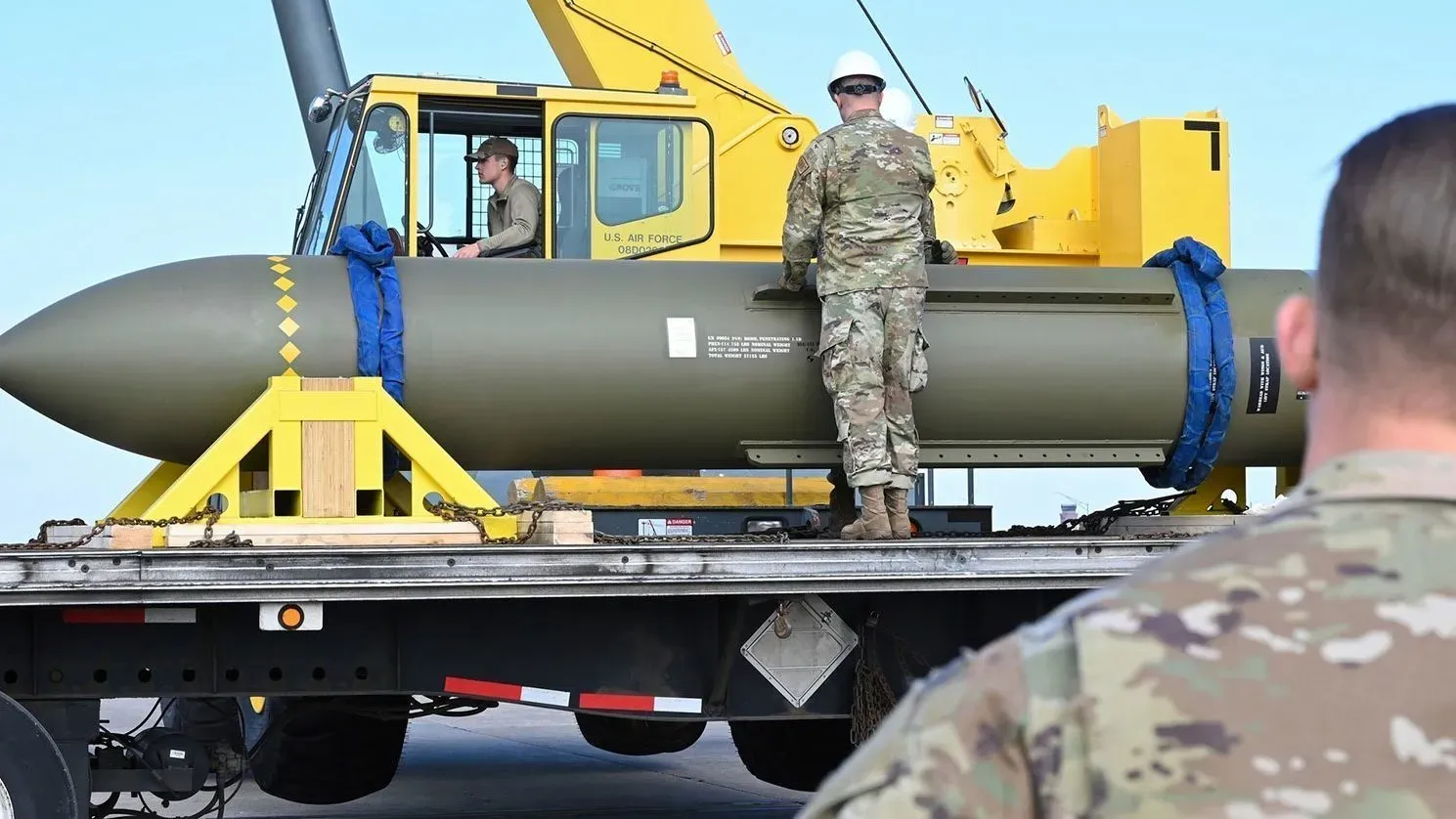 قنبلة GBU-57A/B Massive Ordnance Penetrator تُحمل على شاحنة، مع جنود يرتدون زي الجيش الأمريكي، في إطار الاستعدادات العسكرية.