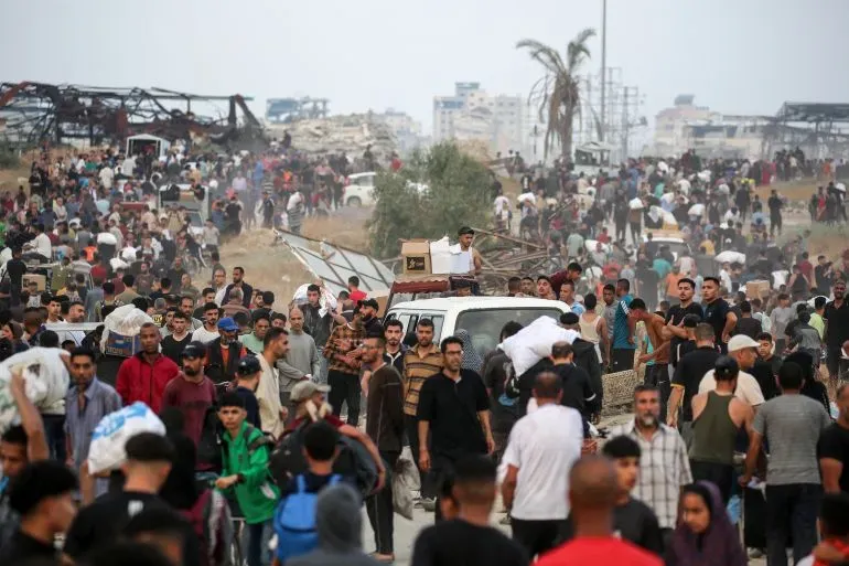 تجمع حشود كبيرة من الفلسطينيين في غزة بالقرب من موقع توزيع المساعدات الإنسانية، بحثًا عن الطعام وسط ظروف قاسية.