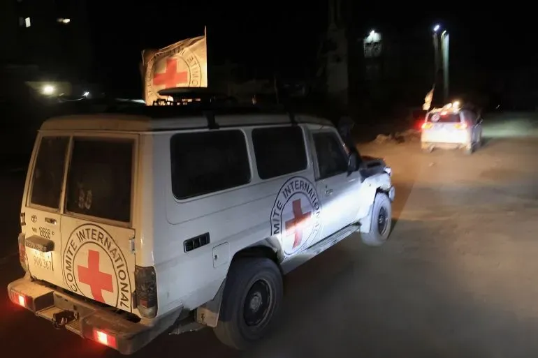 سيارة إسعاف تابعة للصليب الأحمر الدولي تسير في شوارع غزة المظلمة، وسط توترات متزايدة بسبب تصاعد العنف.