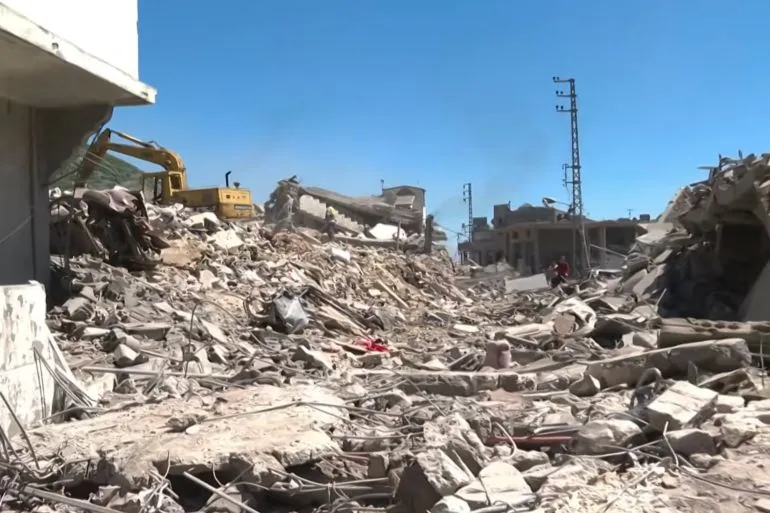 دمار هائل في بلدة مشغرة بلبنان بعد غارات إسرائيلية، مع وجود جرافات تعمل على إزالة الأنقاض وسط مشهد مأساوي للضحايا والمباني المهدمة.