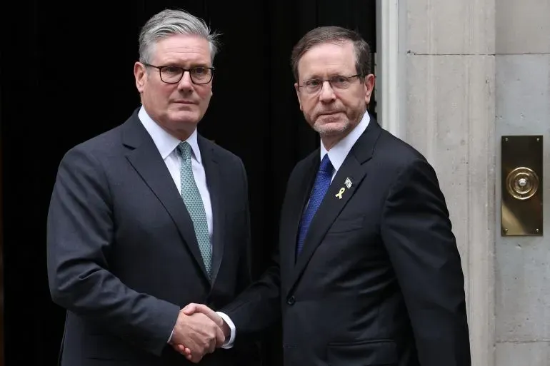 كير ستارمر رئيس الوزراء البريطاني يلتقي مع إسحاق هرتسوغ الرئيس الإسرائيلي، حيث يتبادلان التحية وسط توترات حول الوضع في غزة.