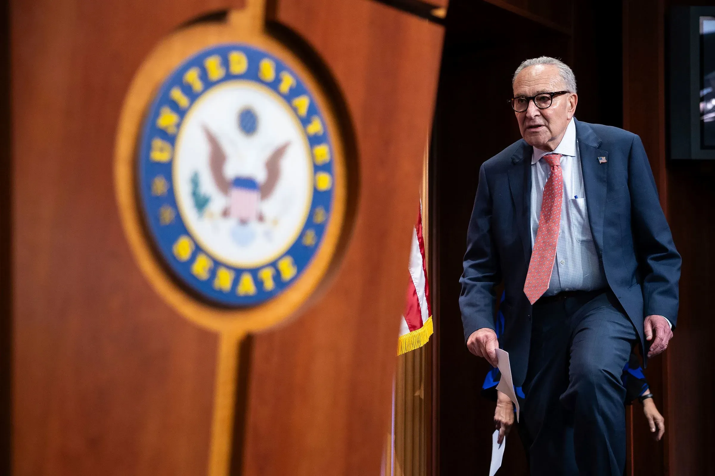 شومر يغادر منصة مجلس الشيوخ، مع شعار المجلس خلفه، وسط أجواء مشحونة حول إغلاق الحكومة والمفاوضات مع ترامب.