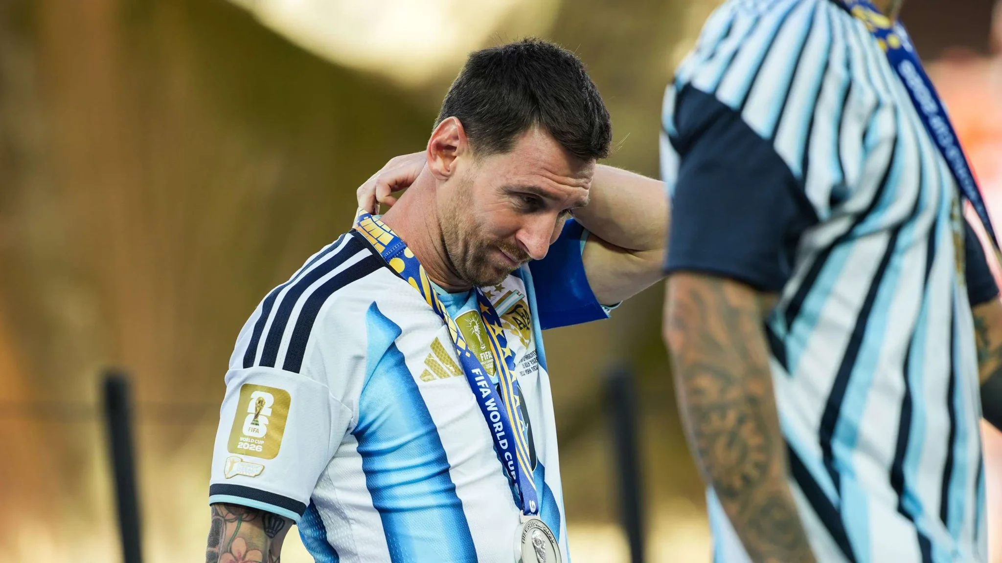 ليونيل ميسي يرتدي قميص الأرجنتين ويضع ميدالية الوصيف بعد خسارة كأس العالم 2026 أمام إسبانيا، معبراً عن حزنه.