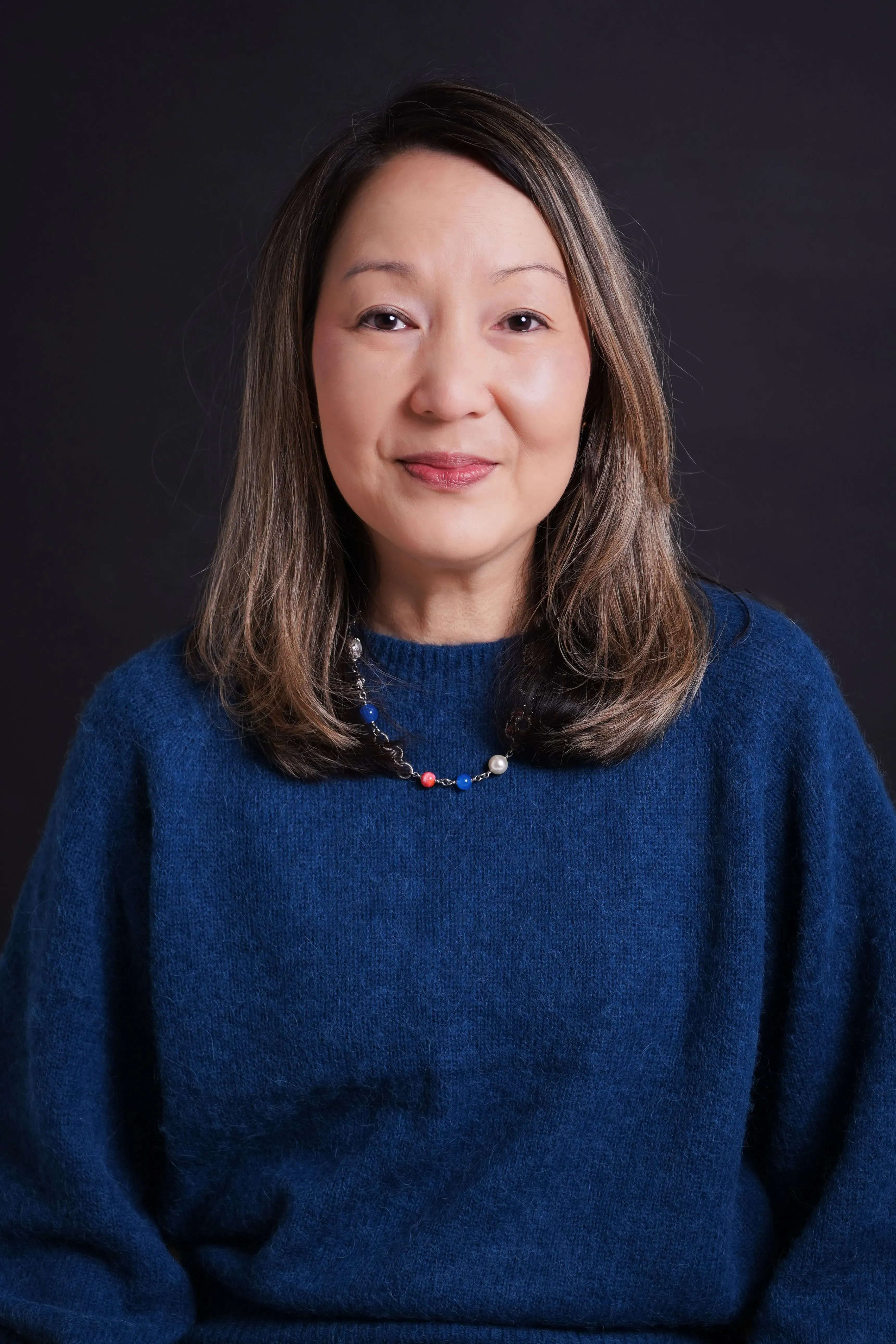 صورة لأخصائية نفسية ترتدي سترة زرقاء، تعبر عن أهمية مشاعر الآباء في تربية الأطفال. تتناول موضوعات الغضب والصحة العاطفية.