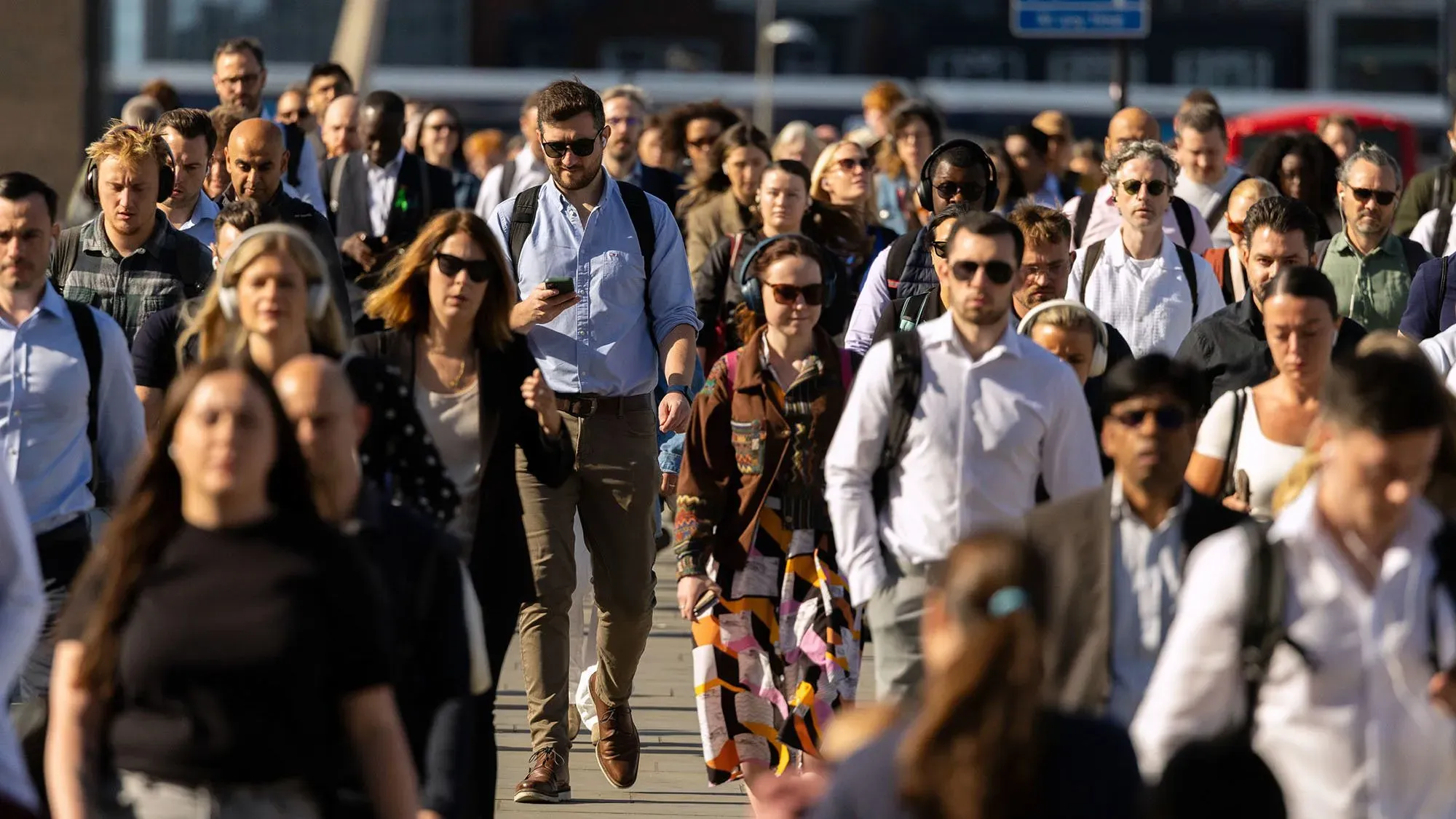 جموع من الموظفين يسيرون في الشارع خلال ساعات الذروة، مما يعكس تحولاً نحو أسبوع العمل لمدة أربعة أيام في المملكة المتحدة.