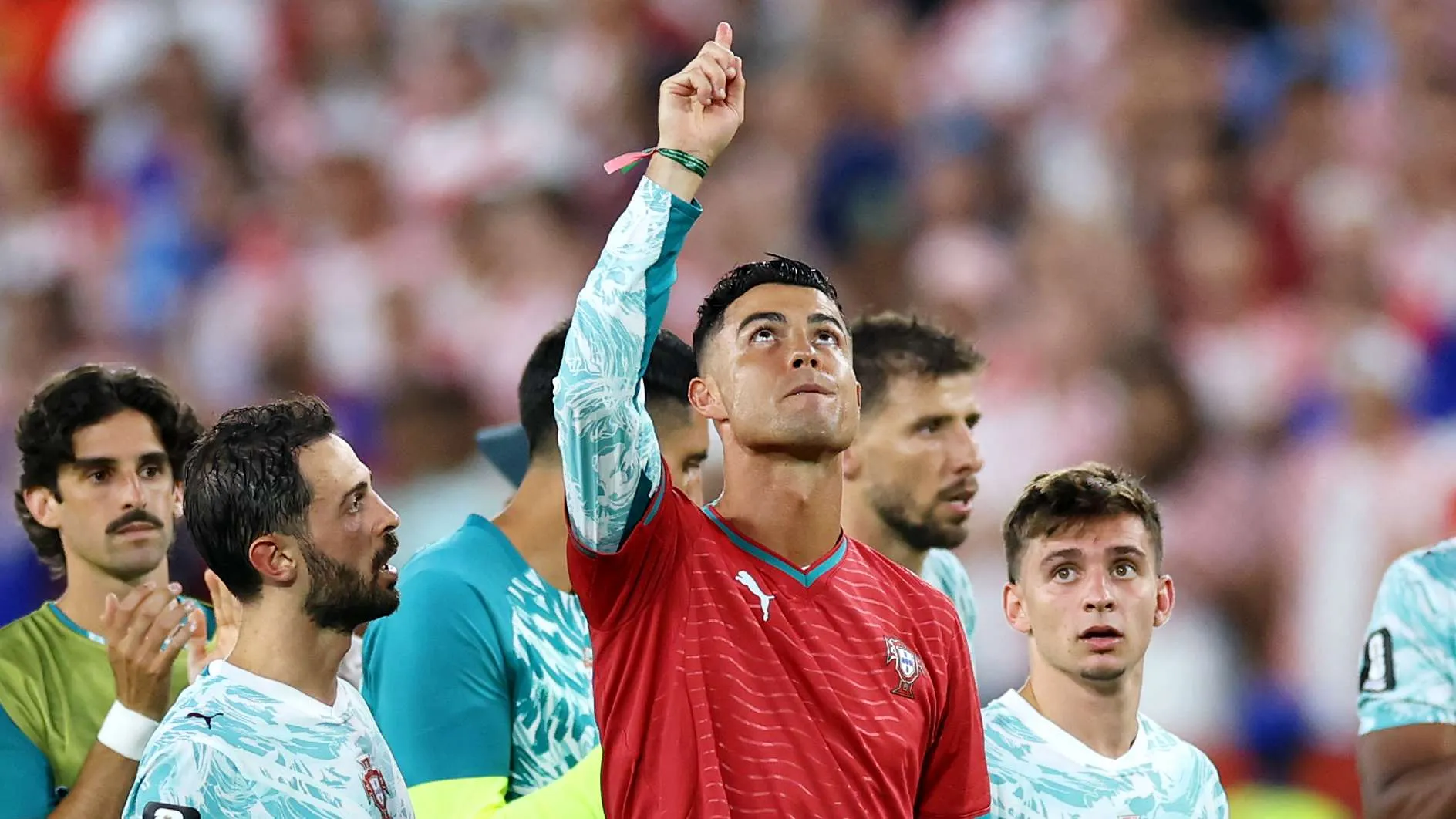 كريستيانو رونالدو يرفع يده بتواضع وسط زملائه في منتخب البرتغال بعد تأهل صعب إلى دور الستة عشر في كأس العالم.