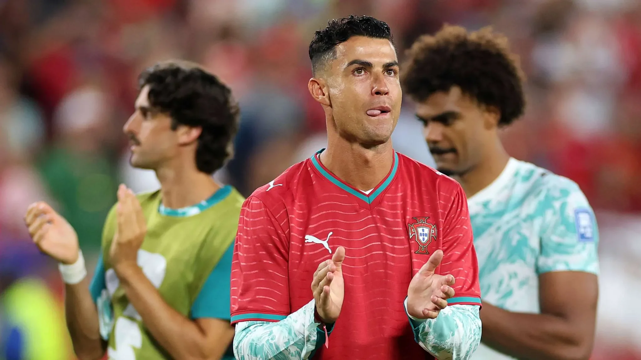 كريستيانو رونالدو يرتدي زي المنتخب البرتغالي يصفق وسط زملائه في ملعب كرة قدم خلال استعدادات مباراة كأس العالم.