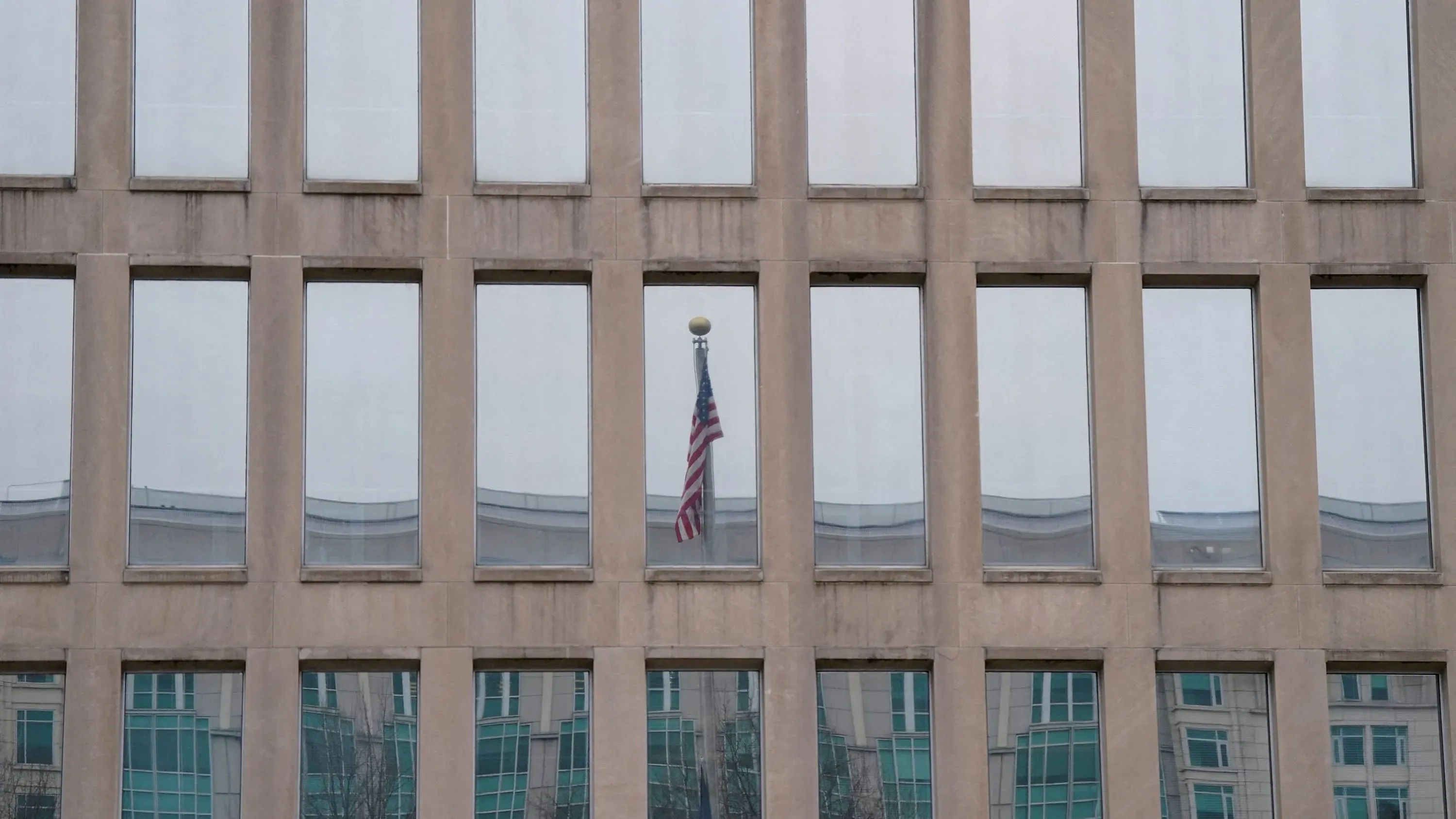 واجهة مبنى مكتب إدارة شؤون الموظفين الفيدرالي، تعكس النوافذ العلم الأمريكي، مما يعكس التوترات الإدارية الحالية.