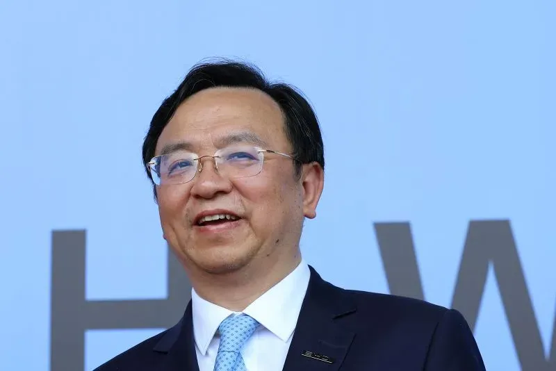 رجل أعمال مبتسم يرتدي بدلة رسمية، يمثل شركة BYD الصينية الرائدة في صناعة السيارات الكهربائية، في حدث رسمي.