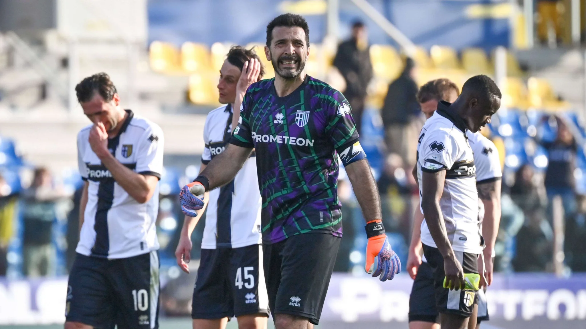 جانلويجي بوفون حارس المرمى الإيطالي يظهر بتعبير وجه يعكس الضغط النفسي وسط زملائه في مباراة كرة قدم.
