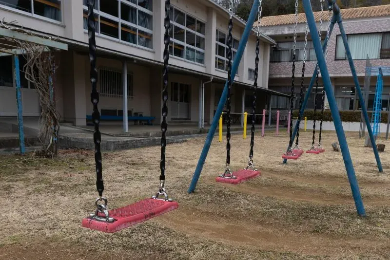 أرجوحة فارغة في حديقة مدرسة يابانية، تعكس انخفاض عدد المواليد وتراجع النشاطات للأطفال في ظل التحديات السكانية.