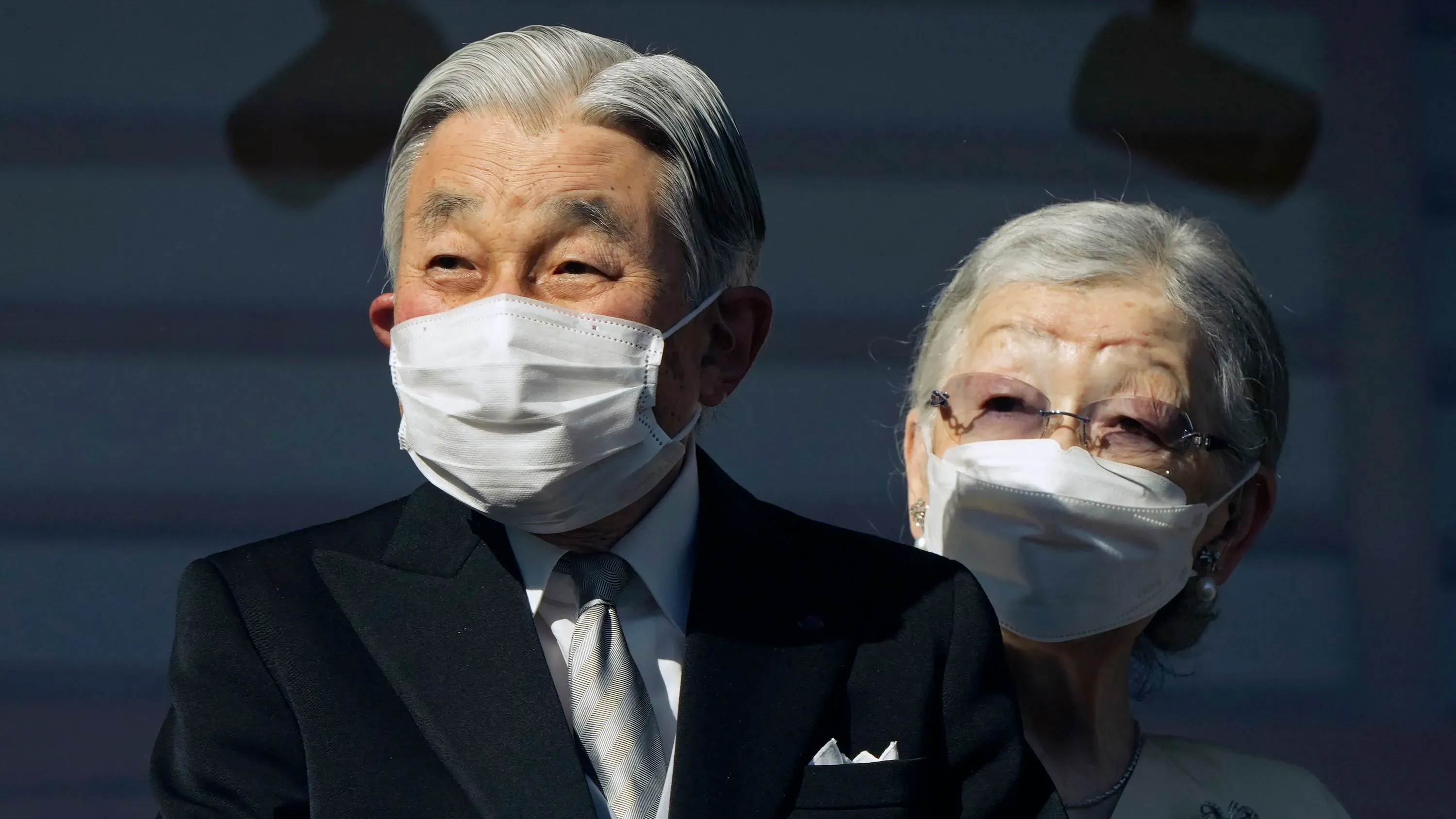 الإمبراطور الفخري أكيهيتو وزوجته، يرتديان كمامات، في مناسبة عامة. يُشار إلى حالته الصحية وأهمية الفحوصات القلبية القادمة.