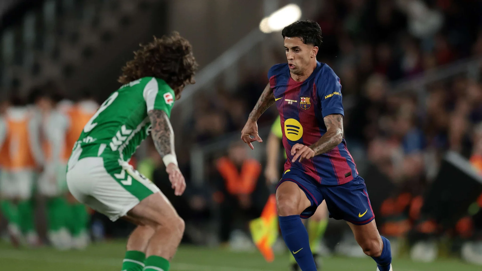 جواو كانسيلو لاعب برشلونة يرتدي الزي الكتالوني يراوغ مدافعًا من الفريق المنافس خلال مباراة حاسمة في الدوري الإسباني.