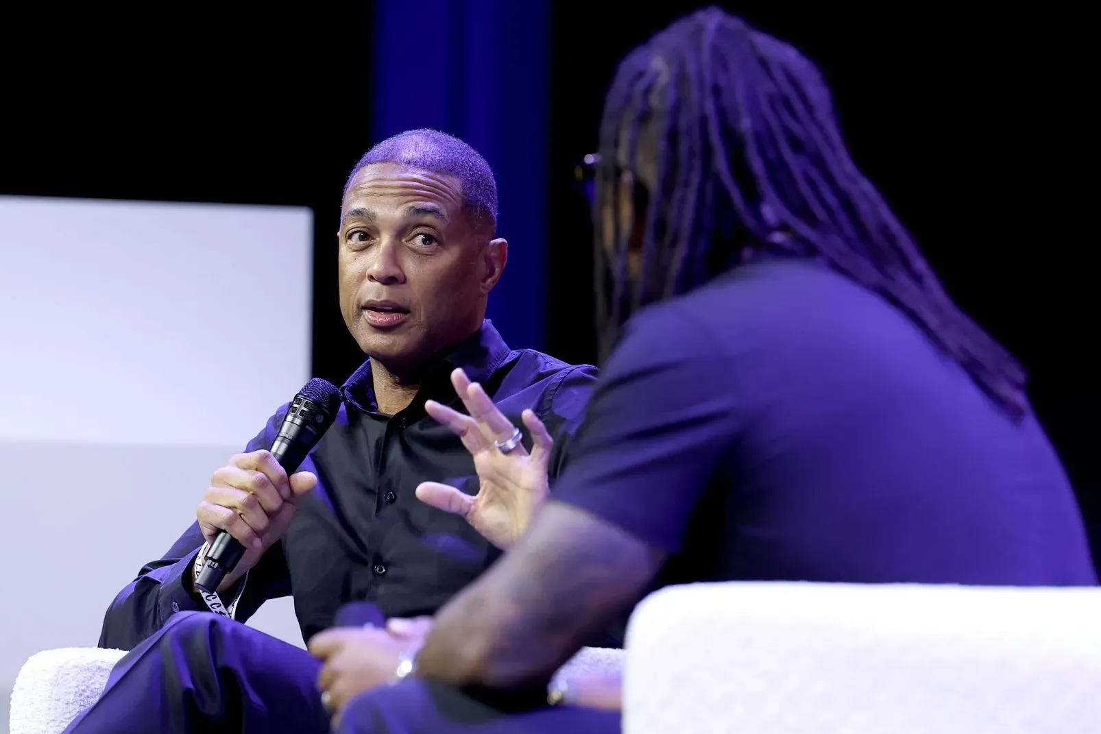 دون ليمون يتحدث في حدث عام، مع التركيز على قضايا الهجرة وحرية الصحافة، وسط أجواء من التوترات الاجتماعية.