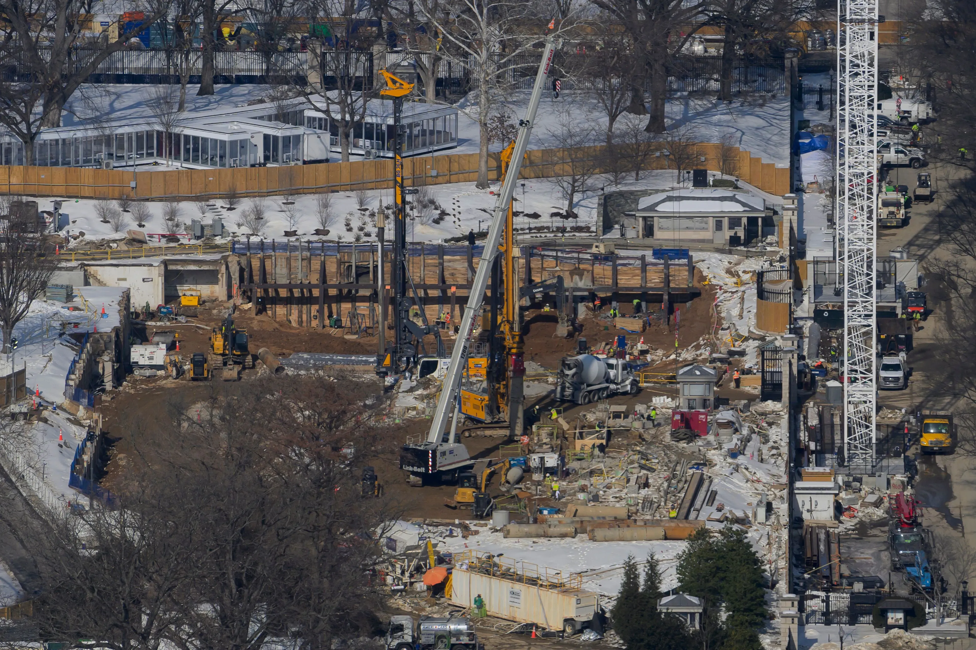 مشهد لموقع بناء قاعة احتفالات جديدة بقيمة 400 مليون دولار بالقرب من البيت الأبيض، يظهر المعدات والعمال في موقع العمل.