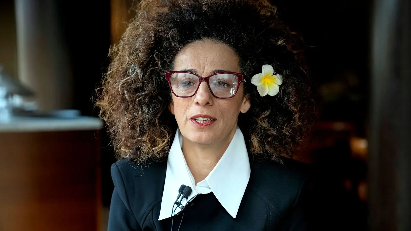 مسيح علي نجاد، الصحفية والناشطة، تتحدث بجدية، مع زهور في شعرها، تعبيراً عن قلقها بعد إدانة المتآمرين لاغتيالها.