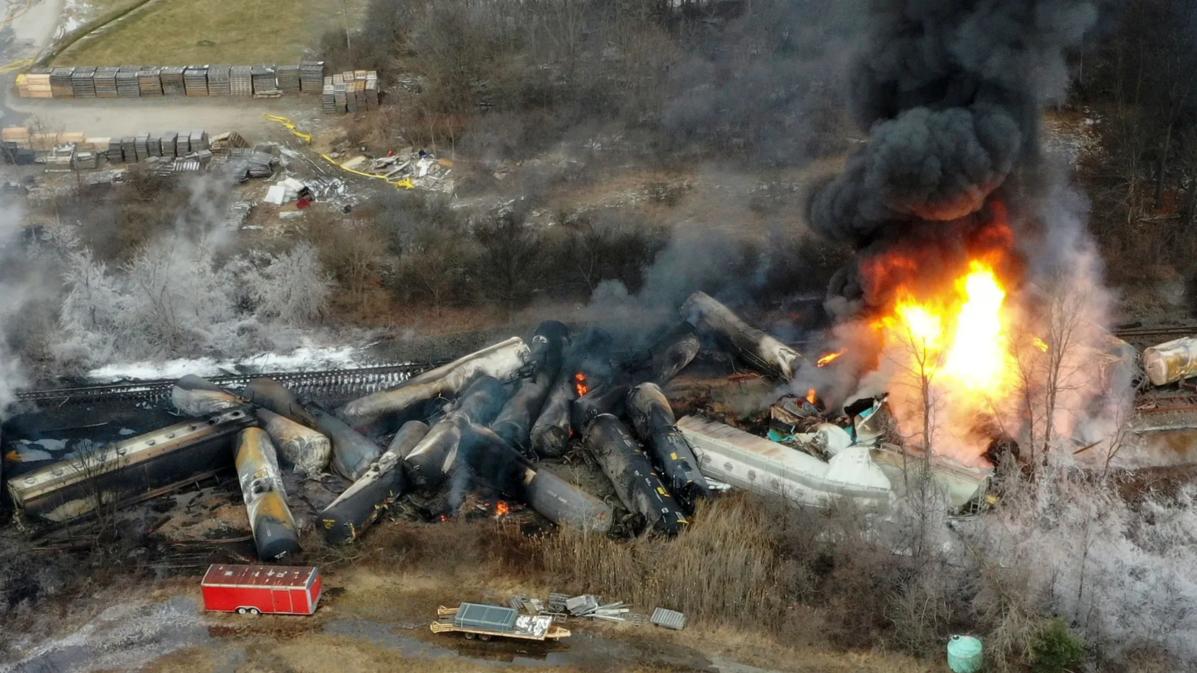حريق هائل ودخان كثيف يتصاعد من عربات قطار مدمرة بعد خروجها عن القضبان في شرق فلسطين، مع وجود عربات صهريجية متفجرة.