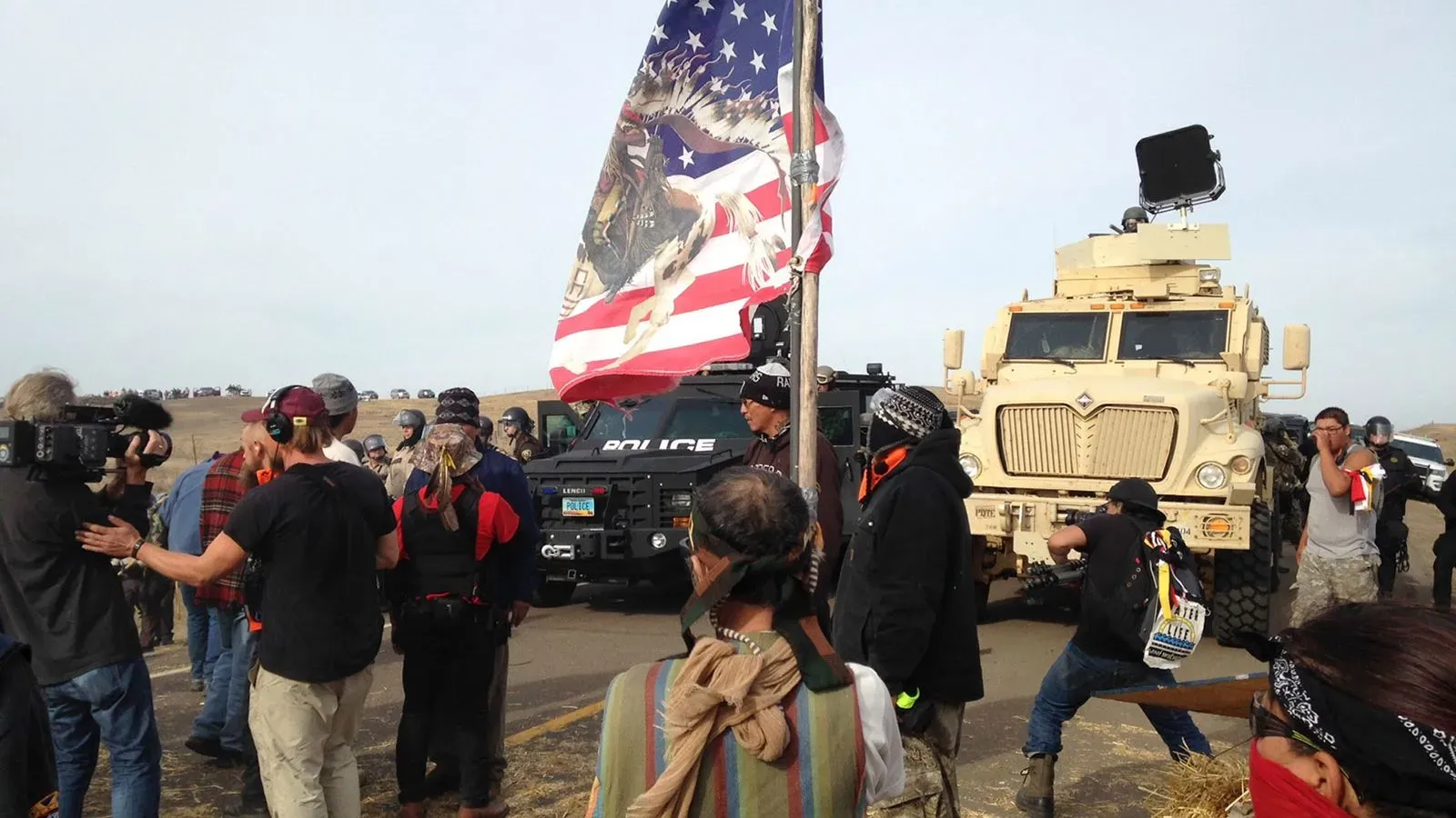 تجمع محتجون ضد خط أنابيب داكوتا أكسيس، مع وجود مركبات الشرطة في الخلفية، خلال احتجاجات في نورث داكوتا.