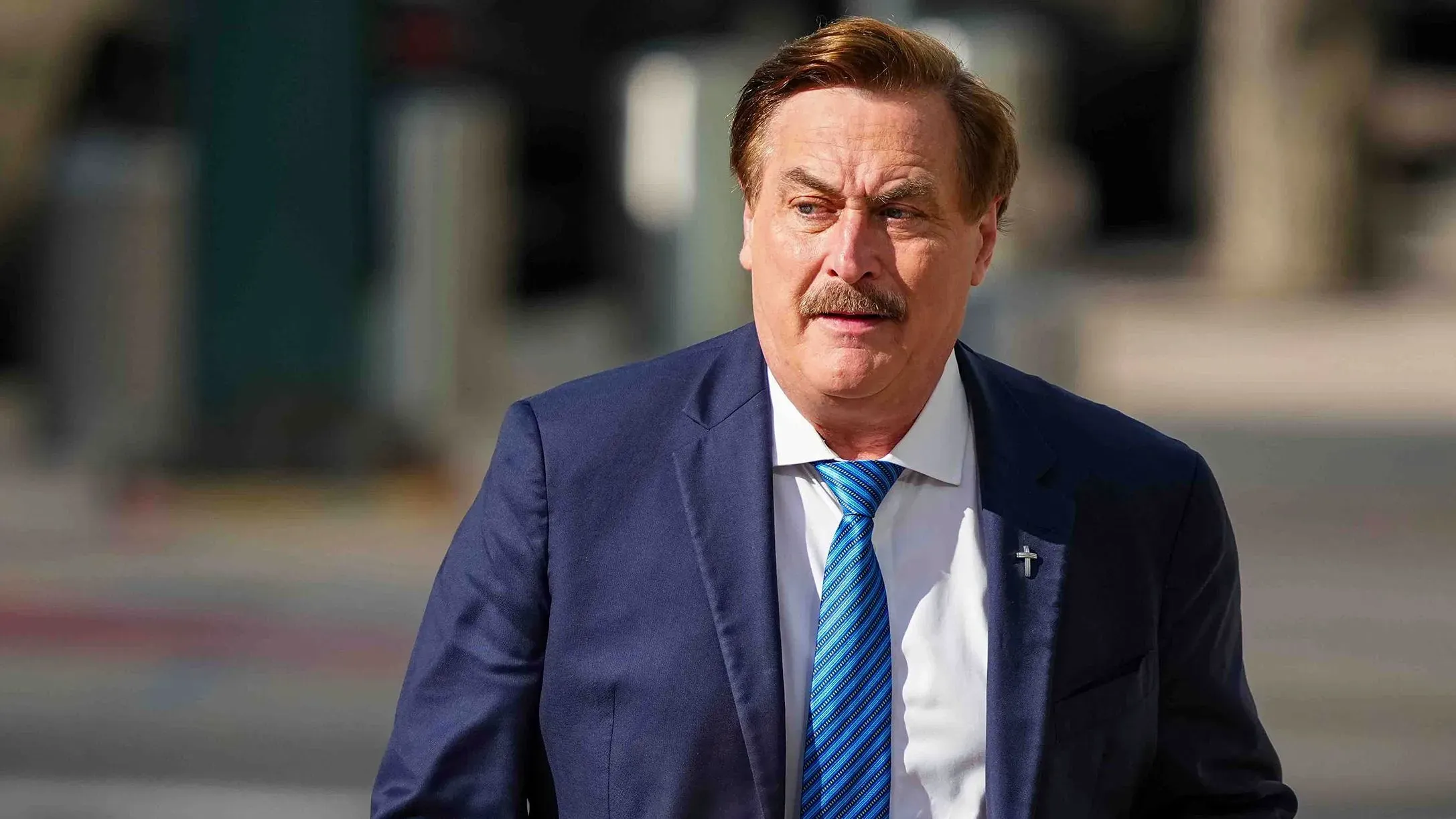 مايك ليندل، مؤسس شركة ماي بيلو، يسير خارج المحكمة مرتديًا بدلة رسمية، حيث يواجه قضايا تشهير تتعلق بانتخابات 2020.