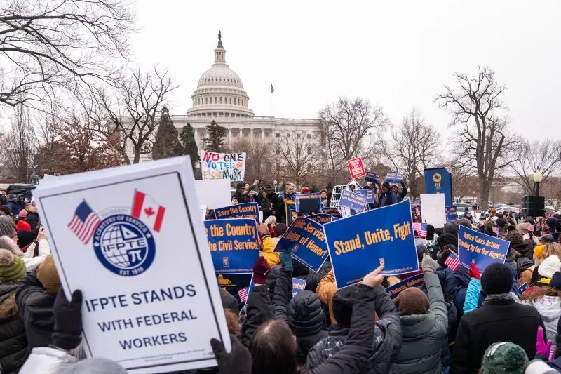 تجمع حاشد أمام مبنى الكابيتول، حيث يحمل المتظاهرون لافتات تدعم حقوق الموظفين الفيدراليين، تعبيرًا عن رد فعلهم على تخفيضات الحكومة.