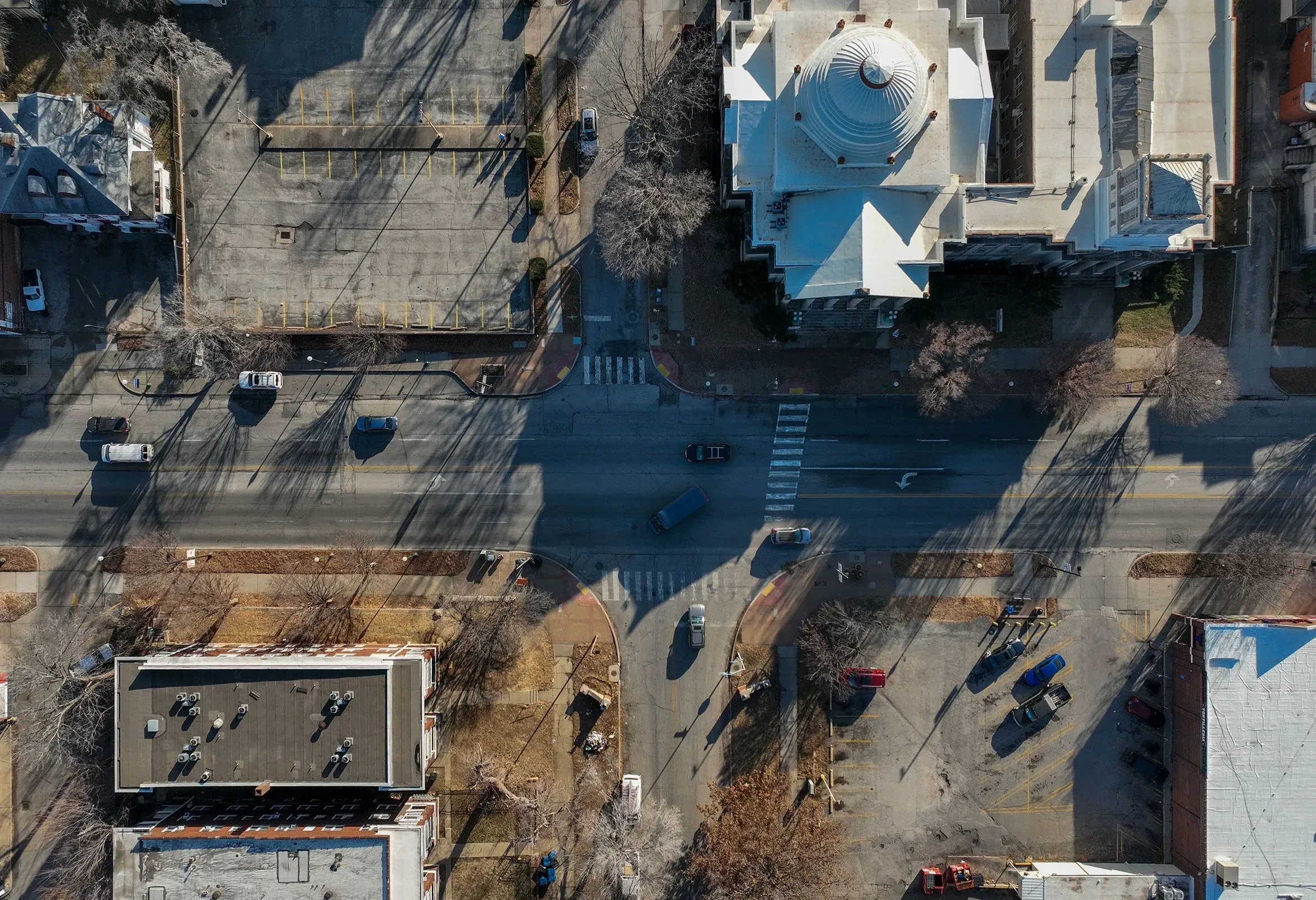 صورة جوية لجادة تروست في مدينة كانساس سيتي، تُظهر الفجوة بين الأحياء، مع وجود مباني ومنطقة انتظار سيارات، تعكس تاريخ الفصل العنصري.