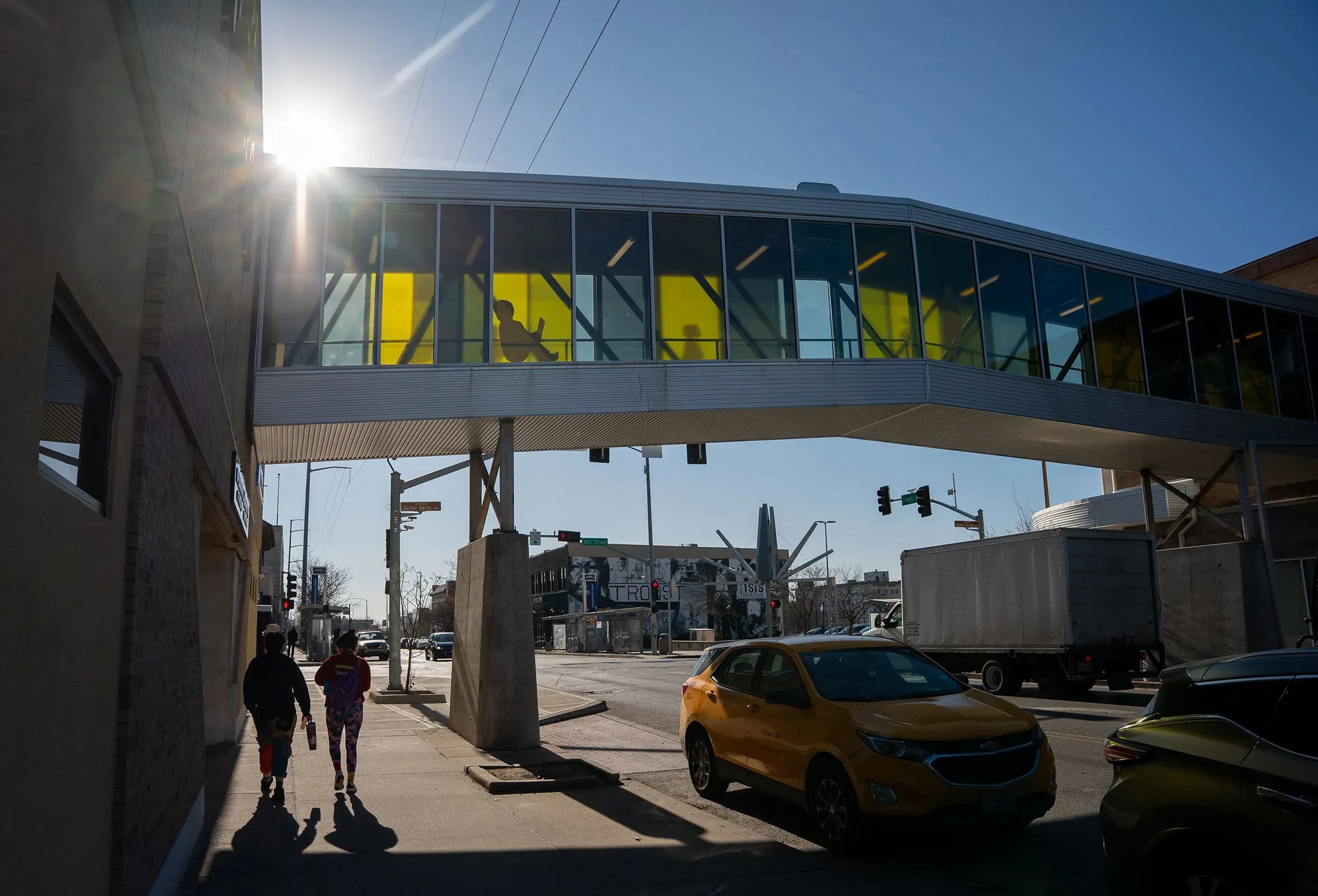 جسر يربط بين مبنيين في حرم منظمة "عملية الاختراق" بكينساس سيتي، مع مشاة يتجولون في منطقة تاريخية تعكس الانقسام العنصري.