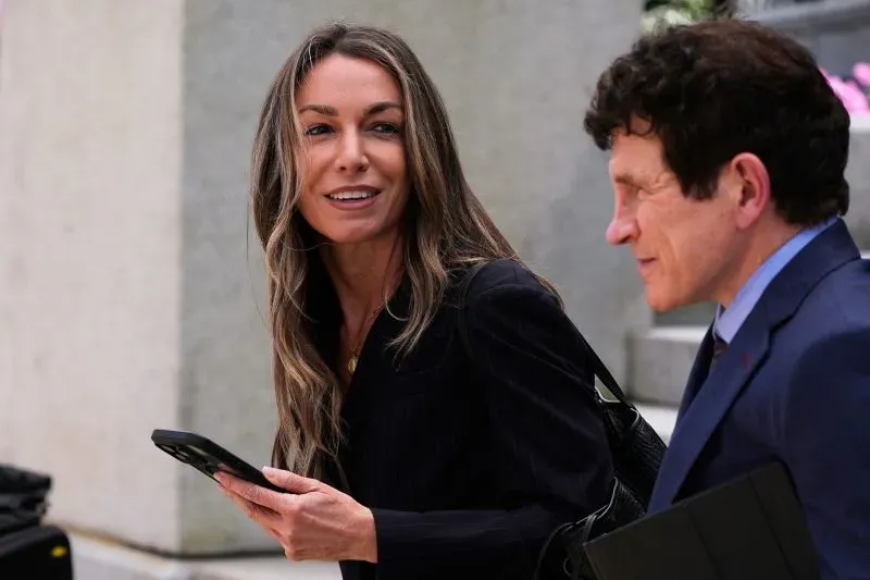 كارين ريد تبتسم أثناء مغادرتها المحكمة مع محاميها، وسط أجواء مشحونة قبل بدء محاكمتها في قضية قتل صديقها الشرطي.