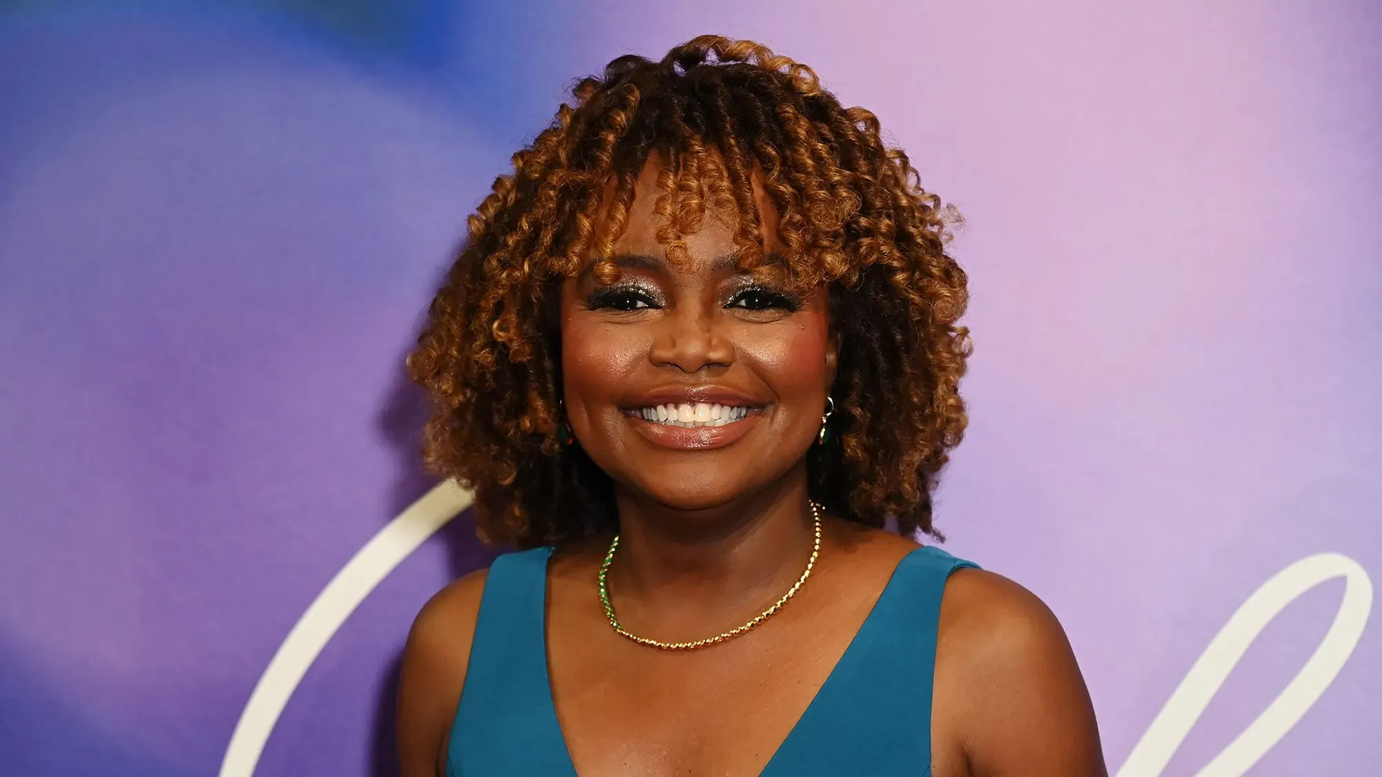 كارين جان بيير تبتسم في حدث، مرتدية فستان أزرق، تعكس تحولها السياسي إلى الاستقلالية وتستعد لإطلاق كتابها الجديد حول السياسة الأمريكية.