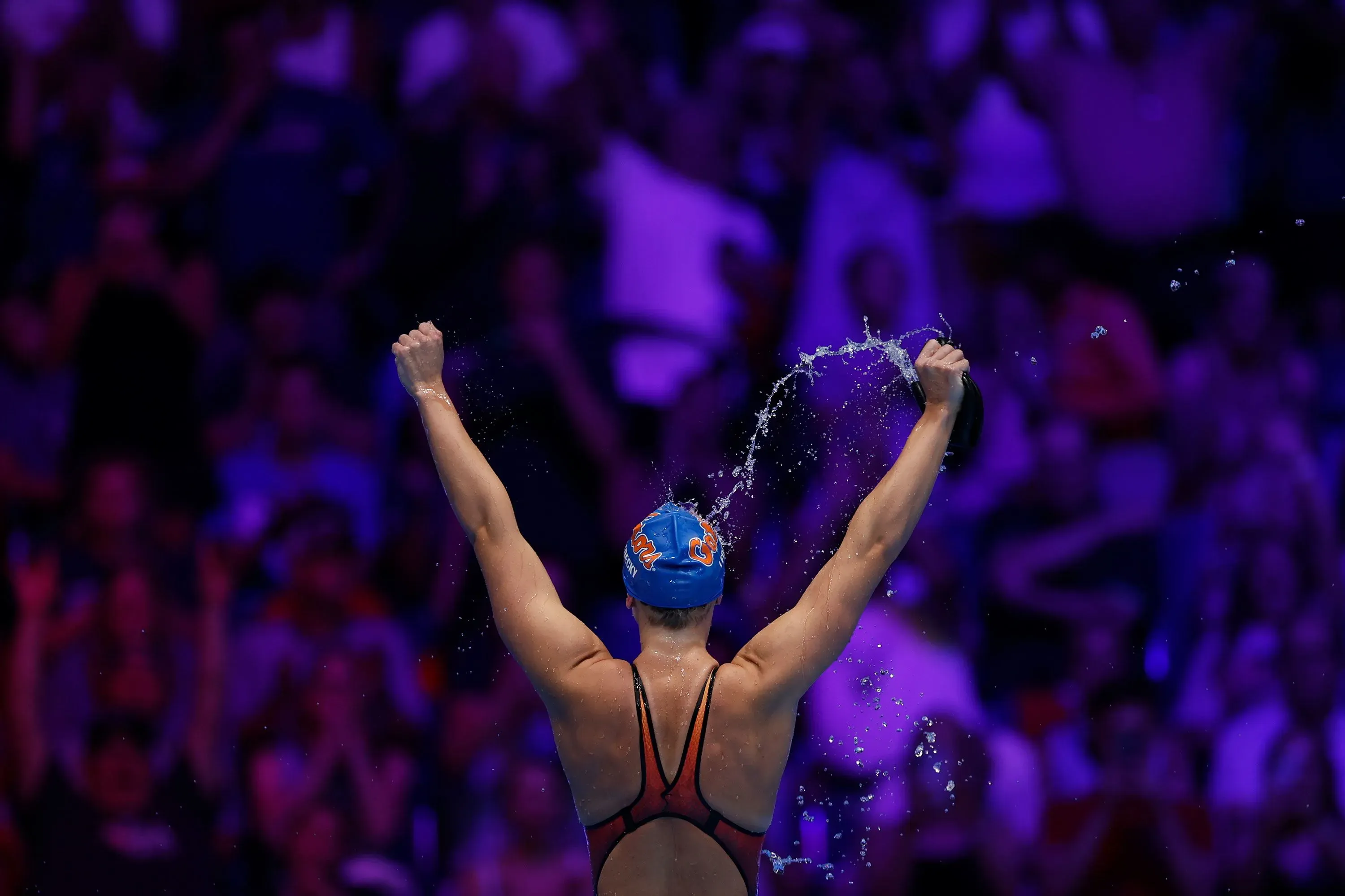 تظهر السباحة كاتي ليديكي وهي تحتفل بفوزها، حيث ترفع ذراعيها في الهواء وسط حشد متحمس، استعدادًا لبطولة العالم للألعاب المائية.