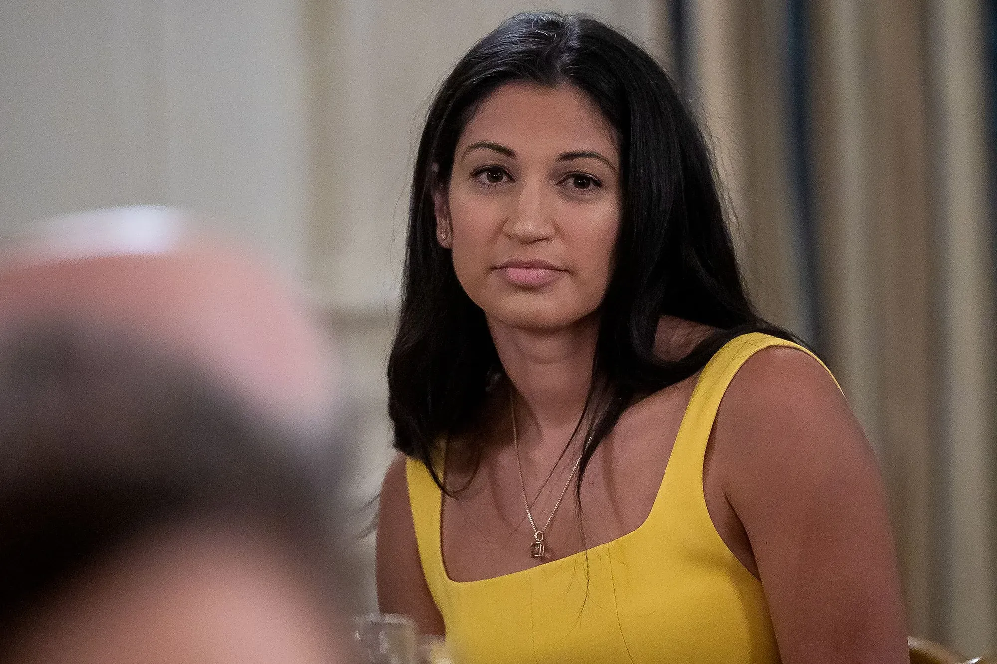 كاتي ميلر، مساعدة سابقة لإيلون ماسك، تتحدث بجدية في حدث رسمي، مرتدية فستانًا أصفر، تعكس اهتمامها بإنشاء بودكاست للأمهات المحافظات.