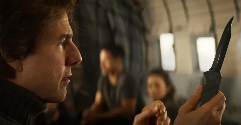 مشهد من فيلم "المحاسب 2" يظهر شخصية رئيسية تحمل سكينًا، مع خلفية توحي بالتوتر والمغامرة.