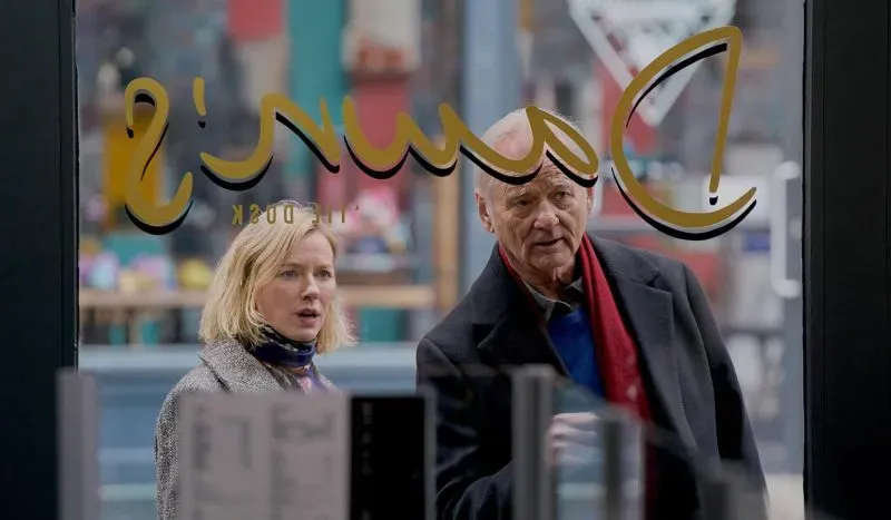 امرأة ورجل مسن ينظران من نافذة مطعم، مع خلفية ملونة تعكس أجواء المدينة، مما يبرز التفاعل بين الشخصيات.