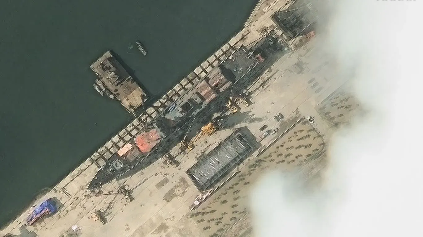 سفينة حربية كورية شمالية متضررة في حوض بناء السفن بعد فشل إطلاقها، مما يثير تساؤلات حول قدرة البلاد على تحديث أسطولها البحري.