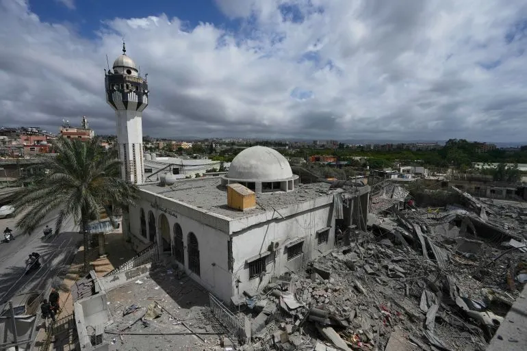تظهر الصورة مسجدًا مدمّرًا في منطقة لبنانية، محاطًا بأنقاض المباني المتضررة، مما يعكس آثار الحرب المستمرة والأزمات الاقتصادية.