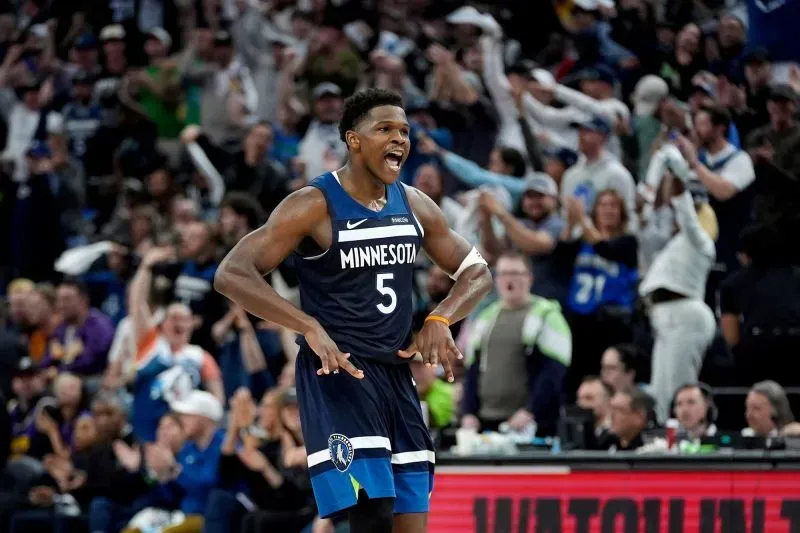 أنتوني إدواردز يحتفل بعد تسجيله نقطة حاسمة خلال مباراة مينيسوتا تمبروولفز ضد لوس أنجلوس ليكرز في البلاي أوف، مع جمهور متحمس في الخلفية.